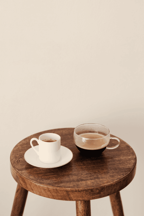 Two cups of carob latte on a wooden tray