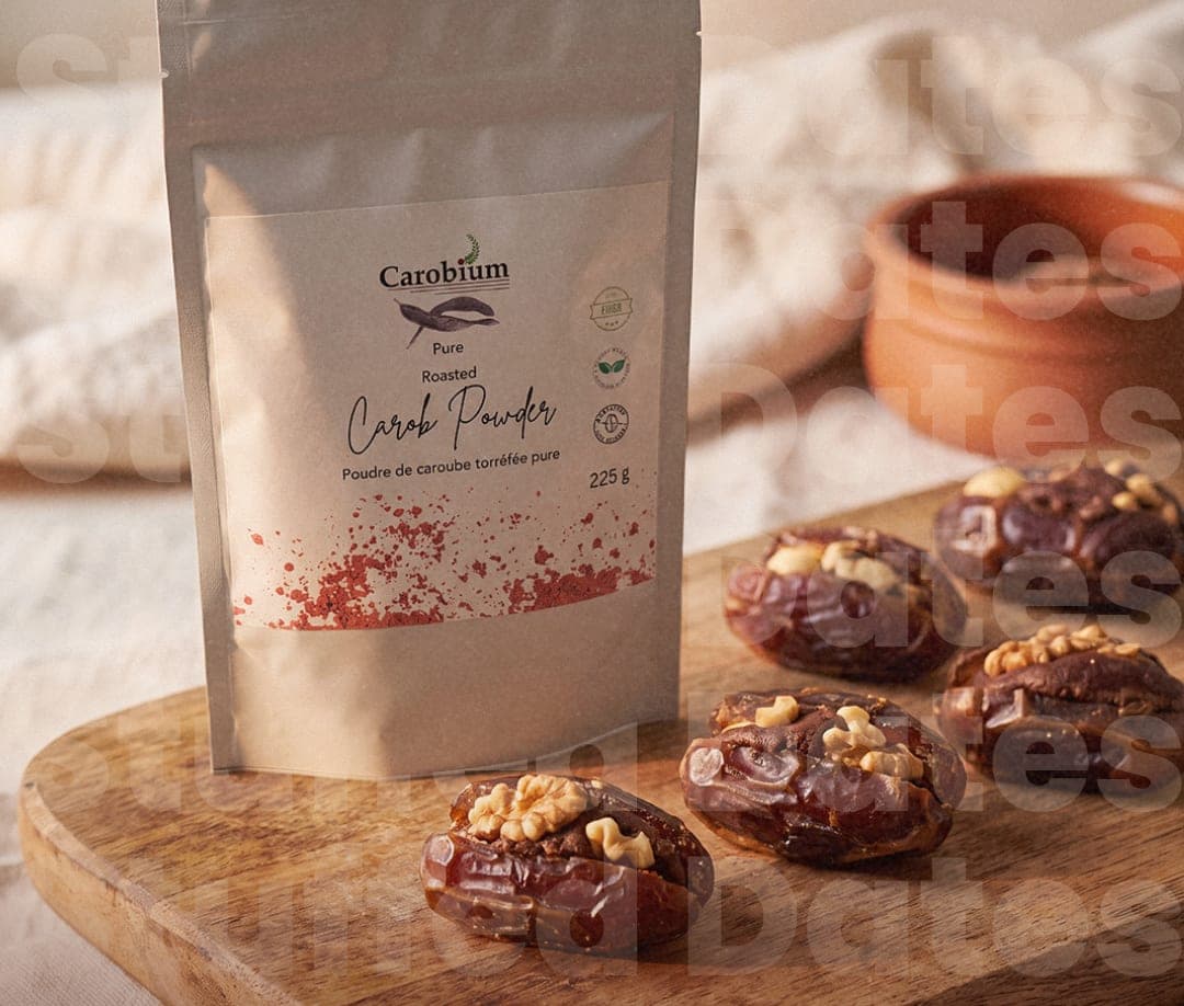 Medjool dates stuffed with carob almond butter and topped with walnuts, beside a pouch of Carobium carob powder